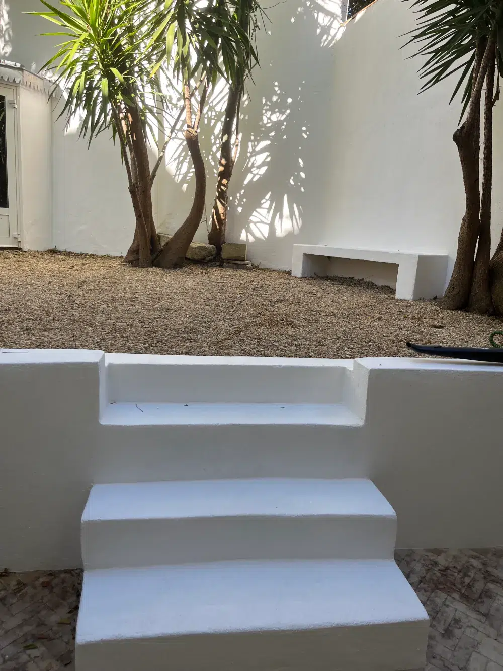 Jardin avec mur et escalier blancs