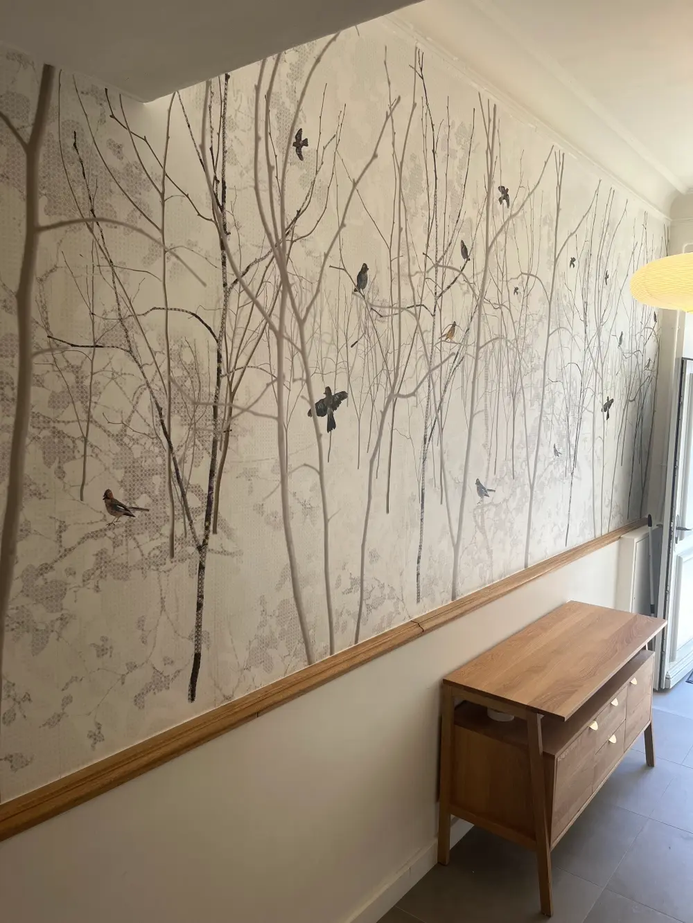 Mur avec papier peint d'arbres et oiseaux